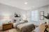 A serene bedroom with a comfortable bed, a workspace desk, and a window for fresh air and sunlight at Lofts at Yard 56.