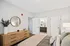 A peaceful bedroom featuring a well-made bed, a contemporary dresser, and a mirror that brightens the space at Lofts at Yard 56.