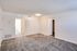 A spacious empty room featuring soft carpet flooring and clean white walls creates a bright and airy atmosphere at Westview Commons Apartments.