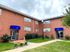 Front view of Dunlea Apartments in Dundalk, MD, featuring a bench and a blue sign for the building.