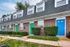 The front view of Bright Meadows Townhomes showcasing inviting green doors on the apartment building's exterior.