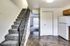 Welcoming kitchen with a refrigerator, stove, and stairs, leading into Bright Meadows Townhomes.