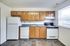 A bright kitchen featuring a refrigerator, stove, and microwave at Bright Meadows Townhomes.