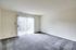 Bright Meadows Townhomes living room featuring an empty space with carpet and a sliding glass door letting in natural light.