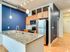 Stylish kitchen at Lancaster Lofts showcasing blue walls and elegant wood floors, blending comfort and modern design.