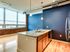 Charming kitchen with blue walls and wooden floors, highlighted by a sleek island from Lancaster Lofts, ideal for entertaining.