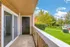 Sliding glass doors open to a charming balcony and a green yard at Hampton Point Apartment.