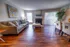 Stylish living room in Hampton Point Apartment showcasing hardwood floors and a charming fireplace for a cozy atmosphere.