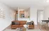 Bright living room in Hampton Point Apartment with a comfortable couch, stylish table, and adjoining kitchen space.