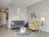 Cozy living room at 500 Park Avenue Apartments featuring a gray couch, yellow chair, and gray coffee table.