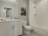 Elegant bathroom in 500 Park Avenue Apartments, showcasing white tiles, a toilet, and a contemporary sink.