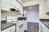 Modern kitchen with white cabinets and a stove top oven, located in the living area of Allyson Gardens Apartments II.