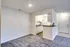A clean, empty kitchen area with white cabinets, located in the living room of Allyson Gardens Apartments II.