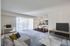 A stylish living room in Allyson Gardens Apartments featuring a cozy couch, sleek table, and a modern television.