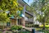 Front view of Allyson Gardens Apartments, featuring greenery with trees and bushes enhancing the building's exterior.