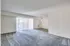 A spacious living room with plush carpeting and sliding glass doors, creating a bright and inviting atmosphere.