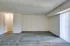 An open, empty living room with a sliding door and carpeted floor, highlighting the charm of Allyson Gardens Apartments.