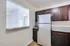 A cozy kitchen in Allyson Gardens Apartments featuring a refrigerator, microwave, and sink for convenient cooking.