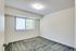 Bright and airy empty bedroom in Allyson Gardens Apartments, showcasing a soft carpet and a large window.