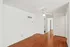 Spacious white room featuring hardwood floors and a ceiling fan, part of the living area in Boston Crossing Apartments.