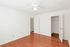 A spacious empty bedroom at Boston Crossing Apartments featuring hardwood floors and clean white walls.