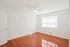 A minimalist empty room at Boston Crossing Apartments, highlighting hardwood floors and bright white walls for a serene vibe.