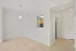 Bright and inviting entryway with beige carpets leading into the cozy dining room and modern kitchen.