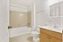 A stylish and contemporary bathroom showcasing a luxurious bathtub with a chic tile surround and a sleek, modern vanity for a fresh, sophisticated look.