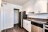 Upgraded kitchen in Westview Commons Apartments featuring stainless steel appliances and warm wood floors.