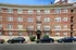 Stunning brick apartment building showcasing timeless elegance with rows of windows and exquisite classic architectural details. This charming structure blends historical beauty with modern appeal, offering a refined living experience.