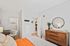 Charming bedroom Lofts at Yard 56 showcasing a bed, dresser, and a window that lets in warm sunlight.