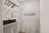 A tidy walk-in closet featuring neatly arranged clothes and baskets at Lofts at Yard 56 two-bedroom model.