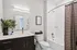 Lofts at Yard 56 secondary bathroom showcases a shower, toilet, and sink in a clean, functional layout.