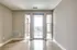 A bright room with large windows and hardwood floors, opening up to a balcony view.