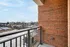 A welcoming balcony with a brick wall, providing a picturesque view and a clear blue sky.