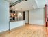 Spacious Lancaster Lofts kitchen and living room with hardwood floors, featuring an open layout and modern design elements.