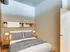 Inviting bedroom at Lancaster Lofts with a comfortable bed, shelves filled with books, and a sunny window.