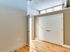 A stylish hallway in Lancaster Lofts with two doors and elegant hardwood flooring.