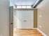 A well-lit hallway in Lancaster Lofts, complete with a door and a modern light fixture, leading to a bedroom closet.