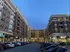 A striking urban apartment complex with lively street-level parking and retail.