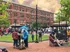 A vibrant community of residents enjoying an outdoor gathering, surrounded by elegant brick buildings.