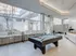 Pool table in a stylish office at 500 Park Avenue Apartments, surrounded by large windows that let in plenty of light.