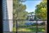 View from a balcony at Allyson Garden Apartments, showcasing vibrant trees and parked cars in a peaceful setting.