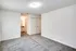 A spacious empty room featuring a soft carpet and clean white walls at Allyson Gardens Apartments II.