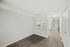 Bright and spacious apartment hallway with a view of a sleek kitchen and sliding doors leading to a backyard.