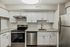 Contemporary kitchen with stainless steel appliances, granite countertops, and white cabinetry.
