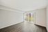 Spacious living room with sleek hardwood floors and large sliding glass doors leading to a patio.