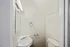 Contemporary small bathroom with a sleek corner sink and minimalist fixtures.