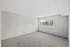 Bright, carpeted room with large window offering a scenic outdoor view.