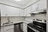 Sleek kitchen with granite countertops, stainless steel appliances, and white cabinetry.